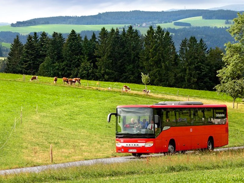 roter Bus fährt in ländlicher Umgebung. Thema Wanderbus zwischen Wutach- und Gauchachschlucht